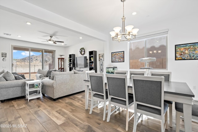 dining room featuring ceiling fan with notable chandelier, recessed lighting, visible vents, and wood finished floors