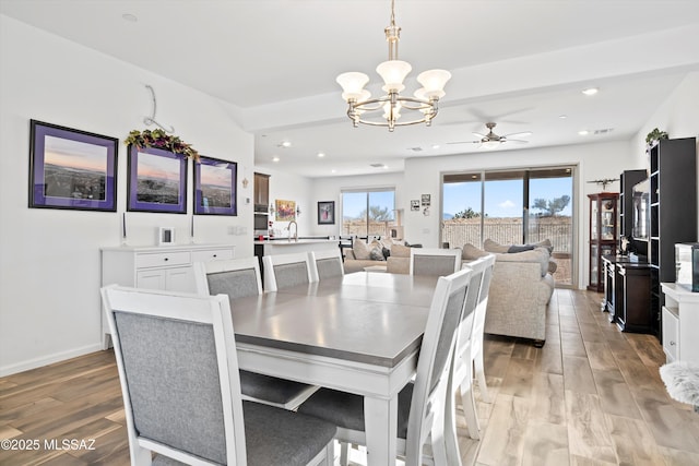 dining area featuring a chandelier, light wood-type flooring, baseboards, and recessed lighting