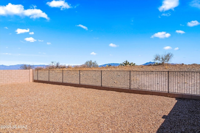 view of yard with fence and a mountain view
