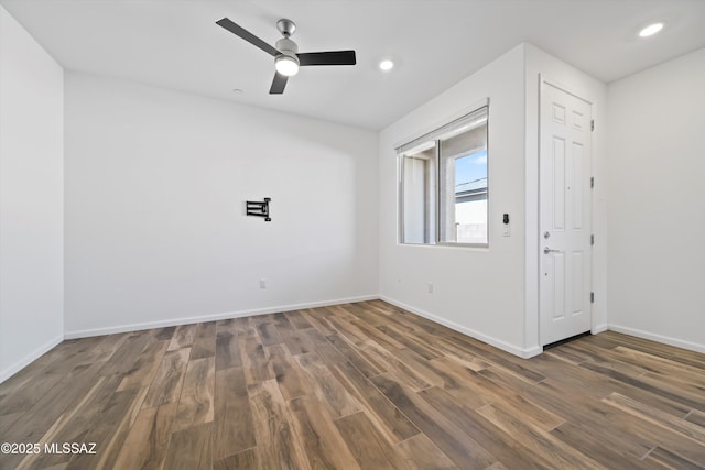 spare room featuring baseboards, dark wood finished floors, and recessed lighting
