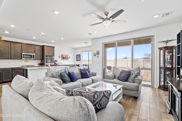 living area with recessed lighting, visible vents, ceiling fan, and light wood-style flooring