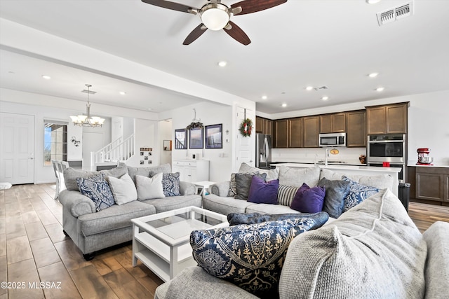 living area featuring dark wood-style floors, stairway, visible vents, and recessed lighting