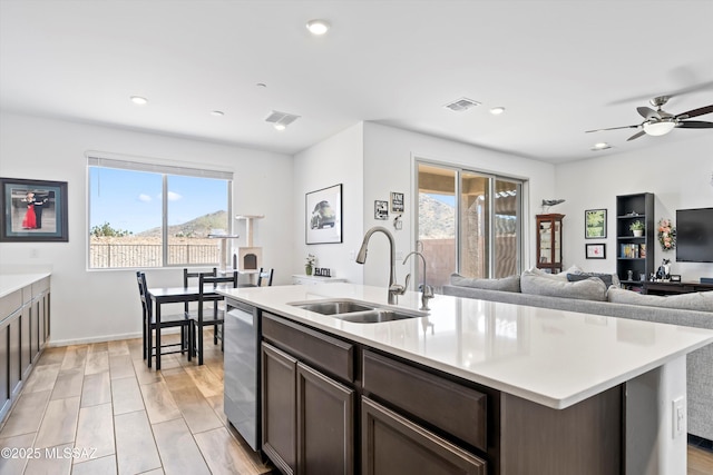 kitchen with light countertops, a sink, visible vents, and dishwasher