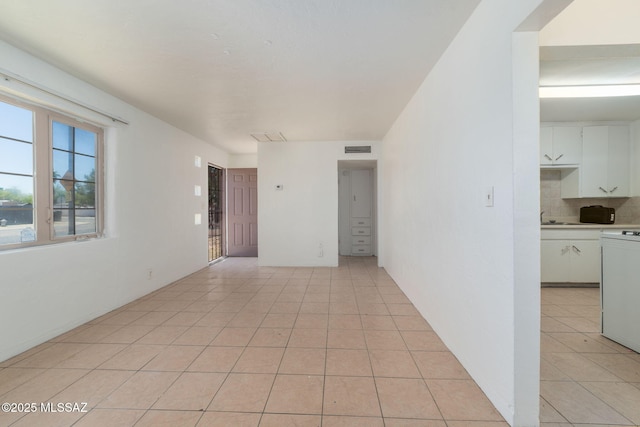 unfurnished room featuring light tile patterned flooring and sink