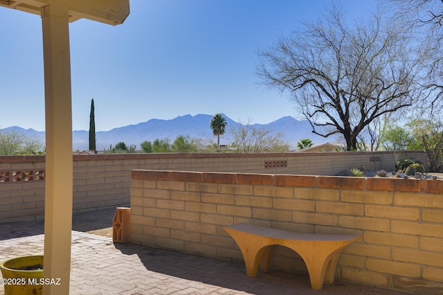 view of patio / terrace featuring a mountain view and fence