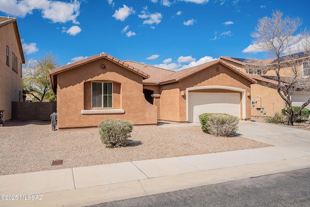 mediterranean / spanish house featuring fence, stucco siding, concrete driveway, a garage, and a tile roof