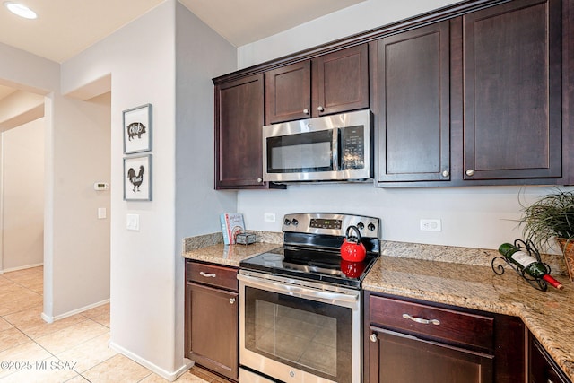 kitchen featuring light stone counters, light tile patterned floors, baseboards, dark brown cabinets, and appliances with stainless steel finishes