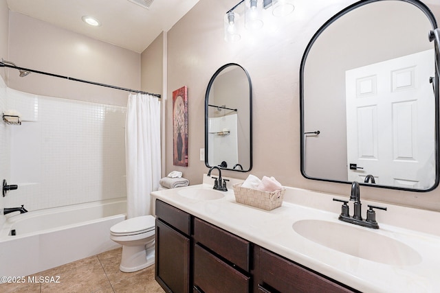 bathroom featuring tile patterned floors, toilet, shower / bath combo with shower curtain, and a sink