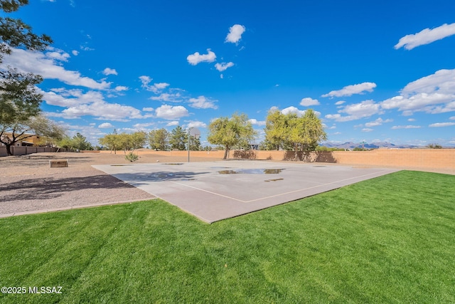 view of sport court with community basketball court, a yard, and fence