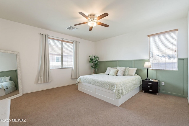 carpeted bedroom featuring baseboards, visible vents, and ceiling fan