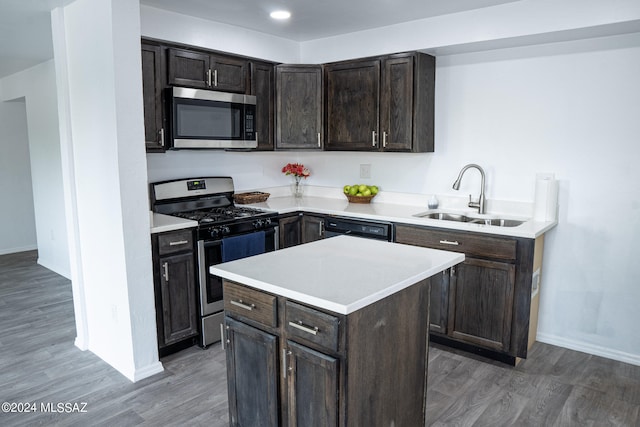 kitchen with a kitchen island, sink, dark wood-type flooring, and appliances with stainless steel finishes