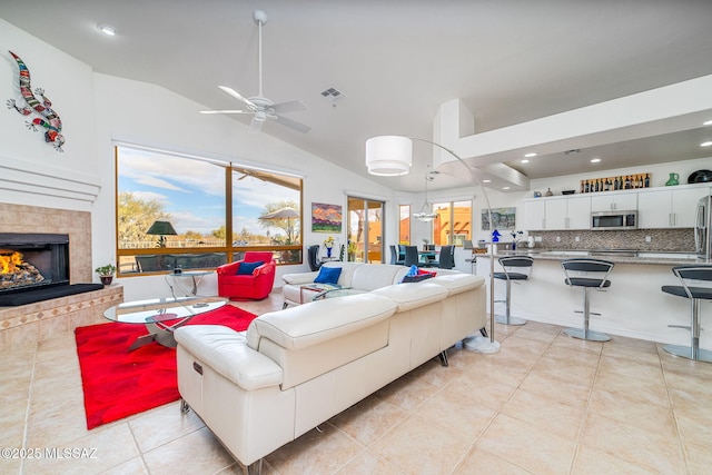 tiled living room with lofted ceiling, a fireplace, and ceiling fan