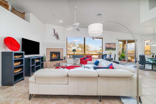 tiled living room featuring a fireplace and ceiling fan