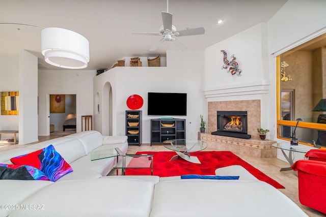 living room featuring ceiling fan, tile patterned floors, and a fireplace