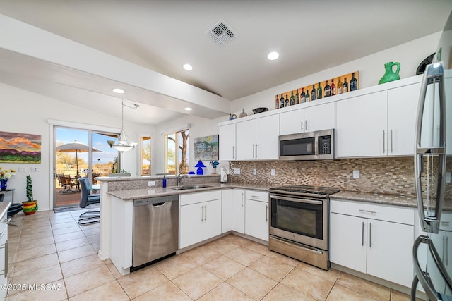 kitchen featuring appliances with stainless steel finishes, tasteful backsplash, white cabinets, decorative light fixtures, and vaulted ceiling