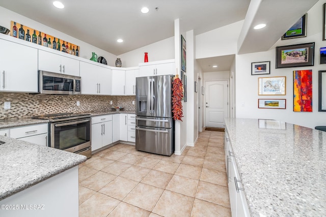 kitchen featuring light stone counters, white cabinetry, decorative backsplash, and appliances with stainless steel finishes