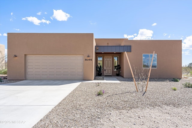 southwest-style home with stucco siding, concrete driveway, and an attached garage