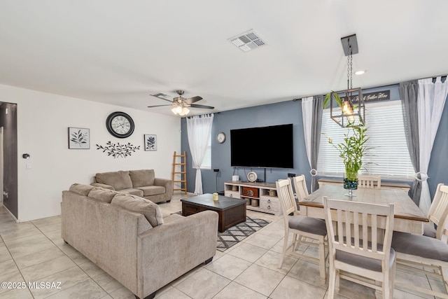 living room with light tile patterned floors, ceiling fan, and visible vents