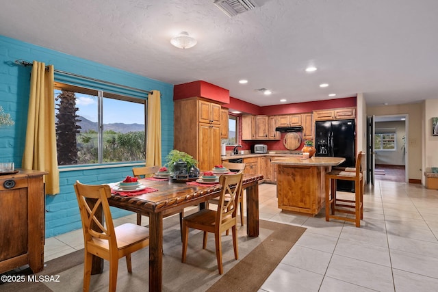 tiled dining space with a mountain view, sink, and a textured ceiling