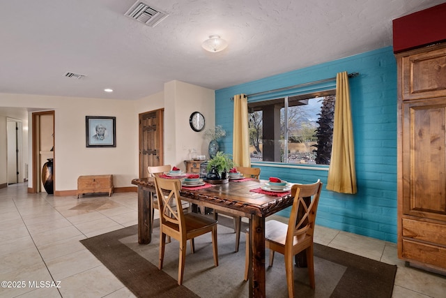 tiled dining space featuring a textured ceiling