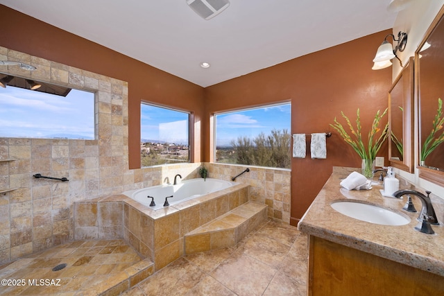 bathroom featuring vanity and tiled bath