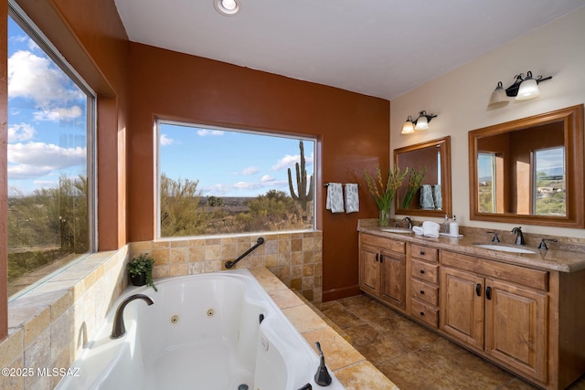 bathroom with vanity and tiled bath