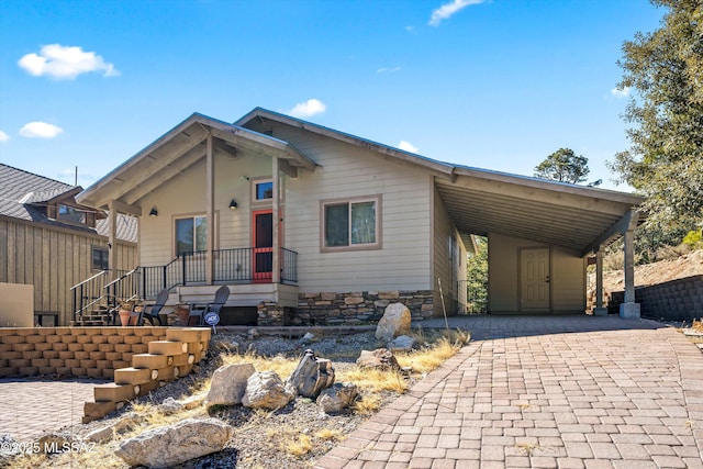 view of front of property featuring an attached carport and decorative driveway