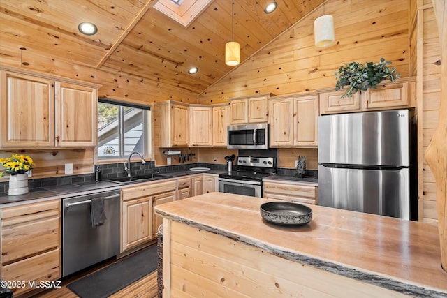 kitchen featuring light brown cabinets, stainless steel appliances, and a sink