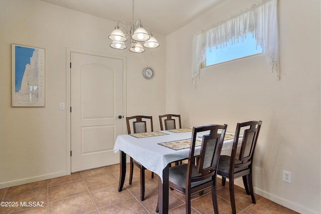 tiled dining room with a chandelier