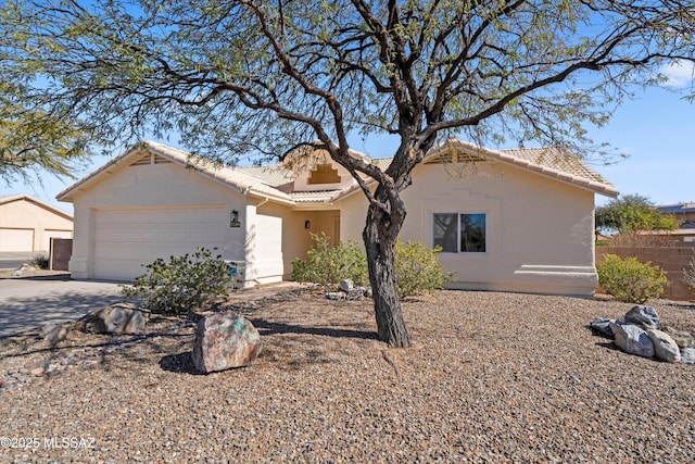 single story home with driveway, an attached garage, a tile roof, and stucco siding