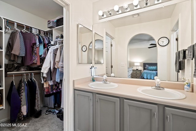 bathroom with double vanity, a sink, visible vents, and connected bathroom