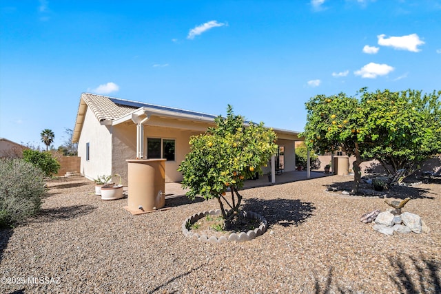 back of property featuring a tile roof, a patio area, fence, and stucco siding