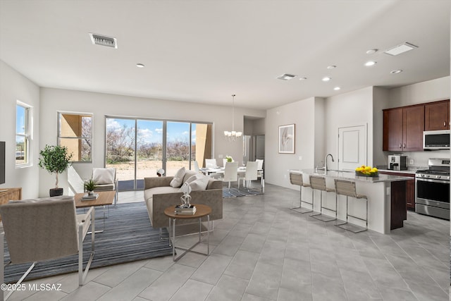 living area featuring a notable chandelier, recessed lighting, and visible vents