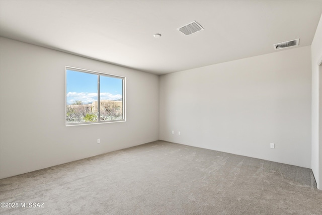 carpeted empty room featuring visible vents