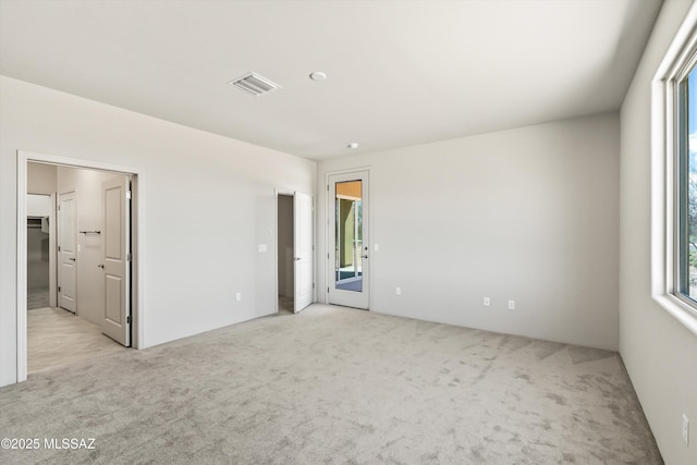 empty room with visible vents and light colored carpet