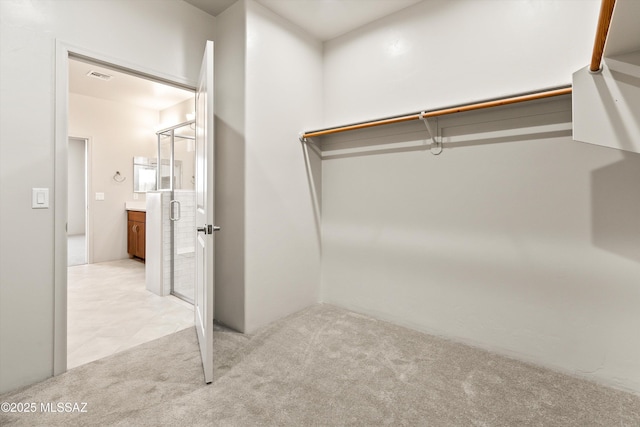 walk in closet featuring visible vents and light carpet