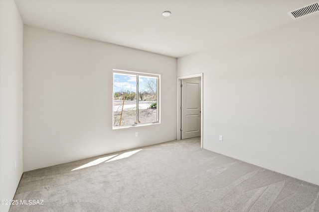 unfurnished room featuring visible vents and light carpet