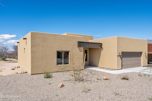 southwest-style home featuring an attached garage and stucco siding