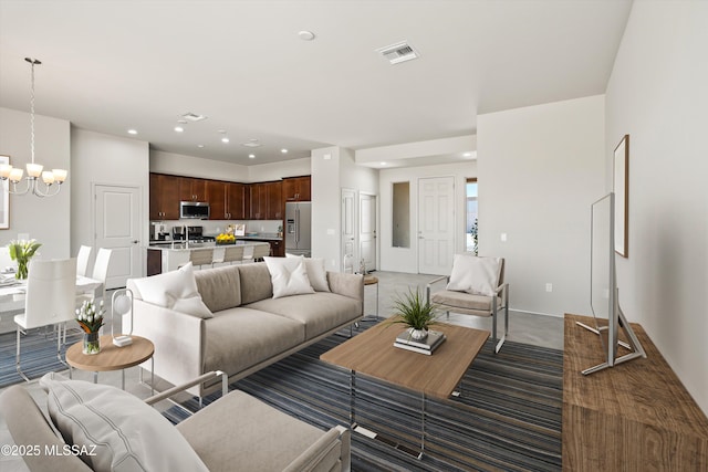 living area featuring visible vents, recessed lighting, dark carpet, and an inviting chandelier