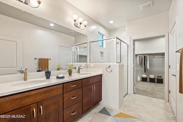 full bathroom featuring double vanity, visible vents, a shower stall, and a sink