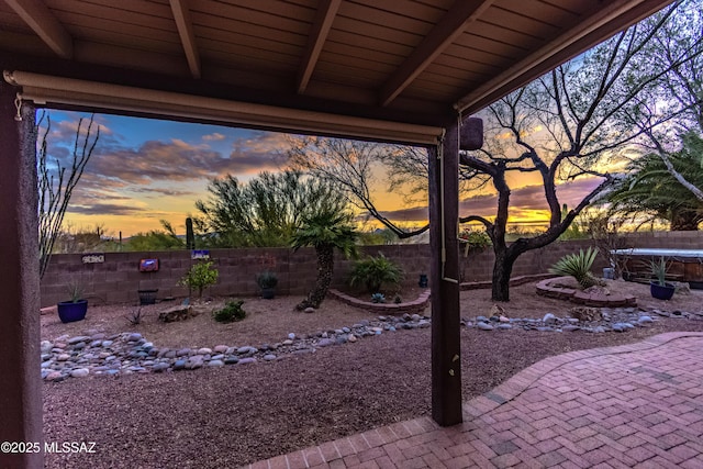 5481 W Cochie Springs St, Marana, AZ 85658 - yard at dusk with a trampoline, a patio, and a fenced backyard