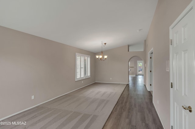 5481 W Cochie Springs St, Marana, AZ 85658 - empty room with arched walkways, vaulted ceiling, wood finished floors, baseboards, and a notable chandelier