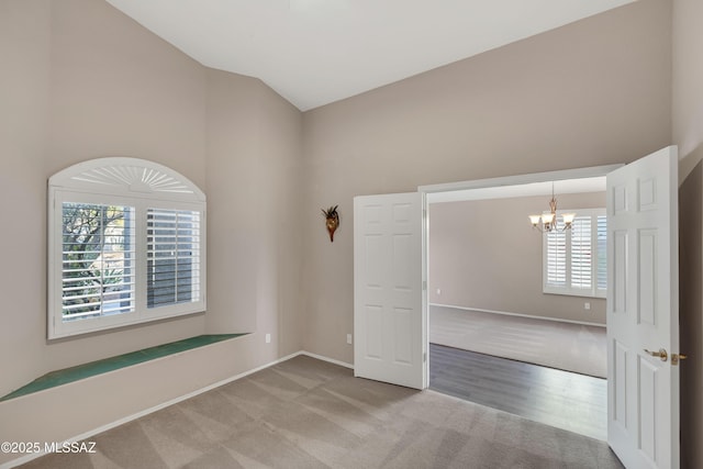 5481 W Cochie Springs St, Marana, AZ 85658 - unfurnished room featuring baseboards, high vaulted ceiling, carpet flooring, and a chandelier