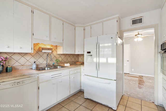 kitchen featuring white appliances, light tile patterned floors, visible vents, decorative backsplash, and a sink