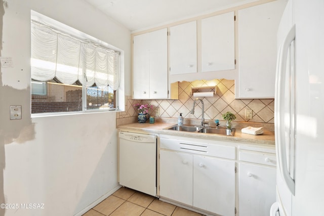 kitchen with light tile patterned floors, white appliances, a sink, and tasteful backsplash