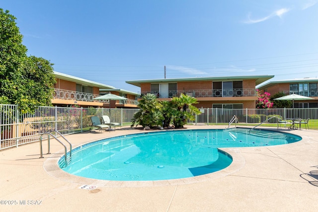 pool with fence and a patio