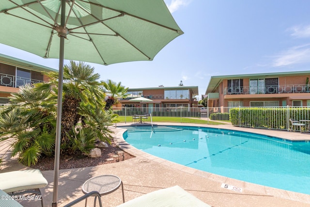 community pool featuring fence and a patio