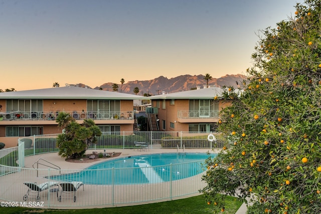 community pool with fence and a mountain view