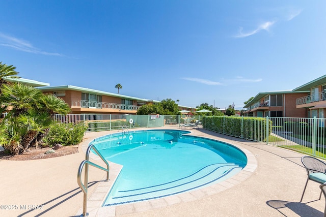 pool with fence and a patio