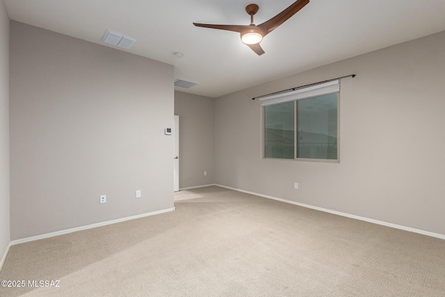 spare room featuring light colored carpet and ceiling fan